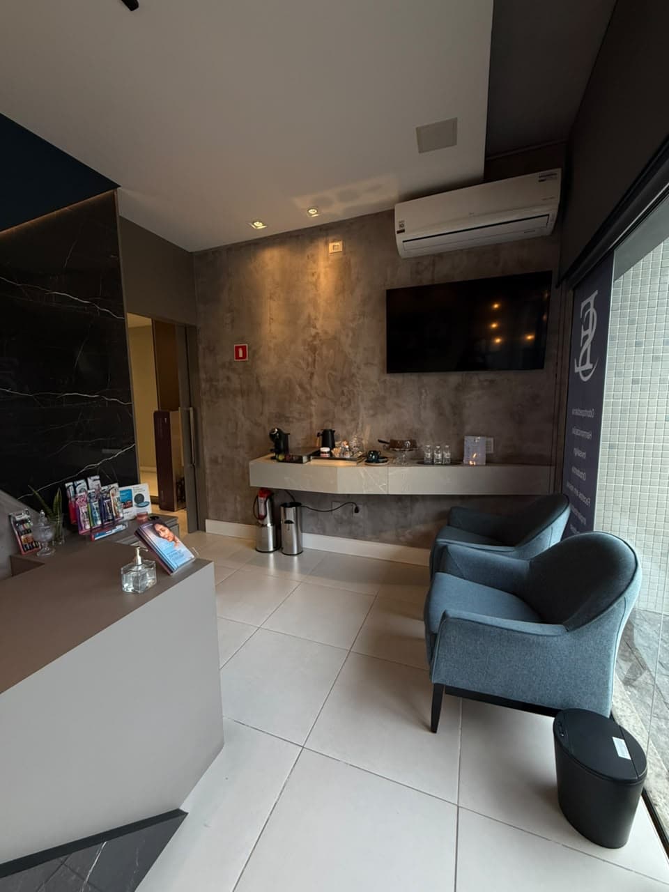 Sala de espera da D'Essenz com poltronas e estação de café