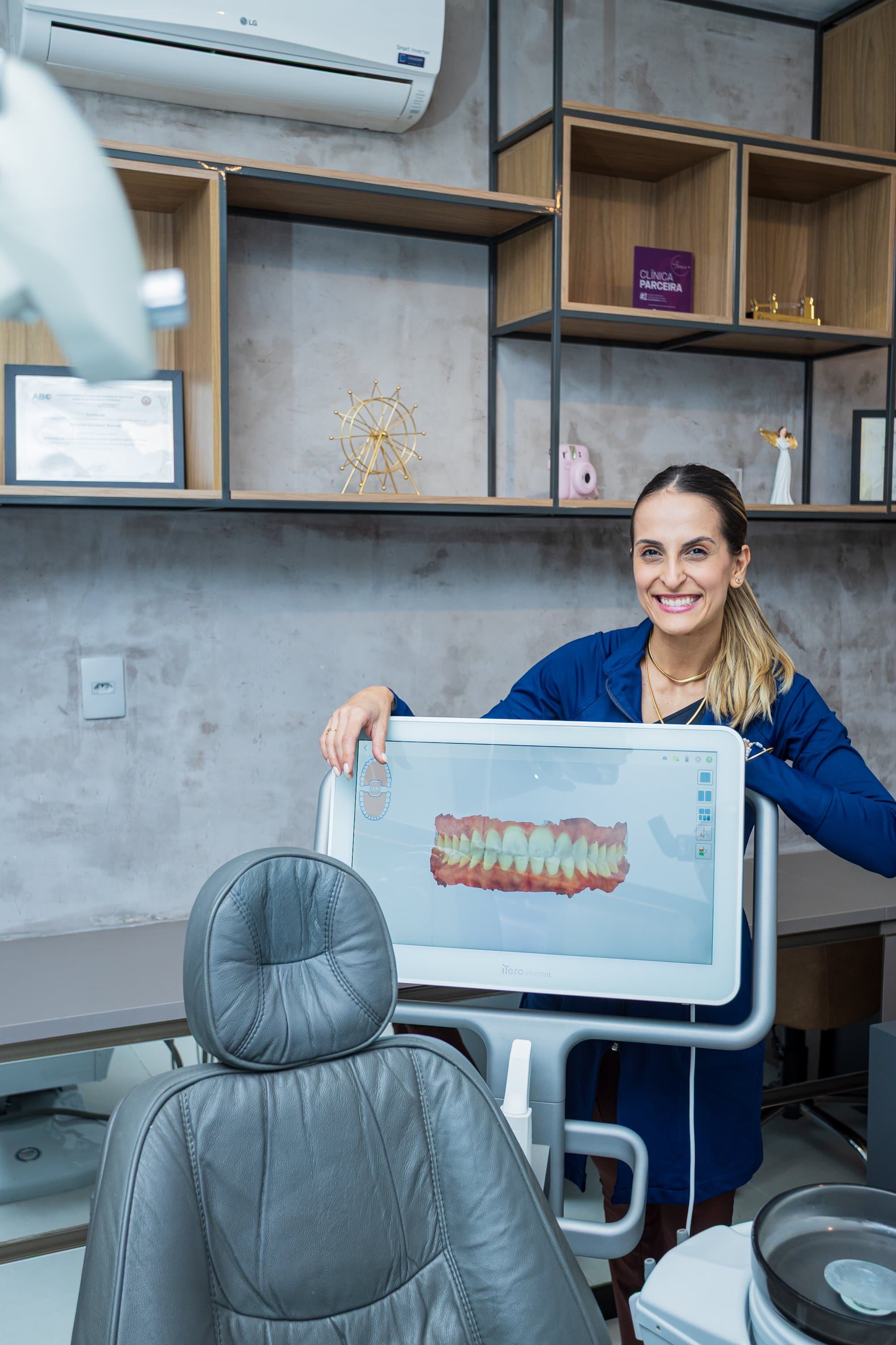 Dentista da D'Essenz apresentando escaneamento intraoral digital em tela durante consulta